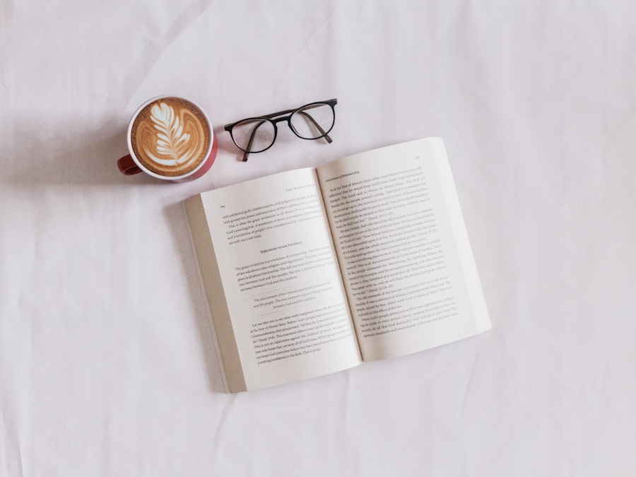 An open book, glasses, and coffee on pale linen